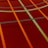 A sports court with intersecting lines in orange and blue, creating geometric patterns on a reddish-brown surface.